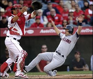 Cleveland's Adam Everett, right, slides into home plate to score on a double by Michael Brantley as Los Angeles catcher Hank Conger awaits the throw in the fifth inning.