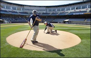 Kyle Leppelmeier, left, and Jim Chambers prepare the pitchers mound at Fifth Third Field on Wednesday in preparation for the Mud Hens home opener Thursday.  