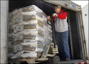 Lavon Herschberger loads a truck with feed corn seed at Rupp Seed in Wauseon, Ohio, to distribute to area farmers getting ready for corn crop planting.
