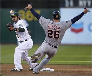 Athletics second baseman Andy LaRoche, left, prepares his double play throw to first over Detroit's Brennan Boesch.