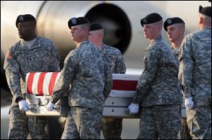An Army carry team moves a transfer case containing the remains of Castalia-native Sgt. 1st Class Charles L. Adkins on Monday at Dover Air Force Base, Del.