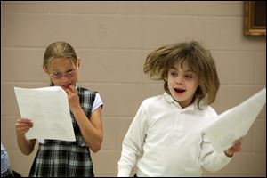 Sarah Demczuk, 9, ponders her lines, and Megan Walters, 8, right, perform during Right-to-Read Week.