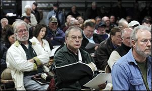 Residents listen to experts' differing opinions on the sounds generated by wind turbines. They gathered Tuesday night at the Riga Township Hall in Riga, Mich.