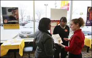 Timisha Butler, 16, left,  gets job information about McDonald's from managers Christine Helm, center, and Abby Timperley at the restaurant in Secor Road's 3300 block during National Hiring Day. The owner plans to add about a dozen employees there this month.