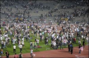 Football fans take to the field earlier this month after an African Champions League match between Zamalek and Tunisian visitor Club Africain in Cairo, Egypt. Police say an unknown number of fans were wounded while rushing a field in Cairo to attack a referee.