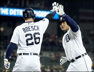 Detroit's Miguel Cabrera, right, is congratulated by Brennan Boesch after scoring when a fly ball got past White Sox center fielder Alex Rios in the second inning.