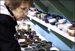 Debbie Lowery of Bradner, Ohio, looks over some of the bowls for sale.