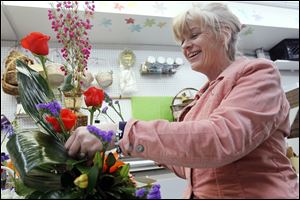 Mary Beth Lorenzen creates a flower arrangement at Schramm's Flowers. Sandy Sack, who owns the West Toledo florist shop, says she expects her store to sell out of Easter lilies this year.