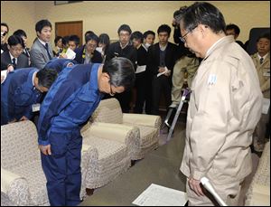 Tokyo Electric Power Co. President Masataka Shimizu, left, bows in apology to Gov. Yuhei Sato, right, of Fukushima prefecture Friday during their meeting at the prefectural office at Fukushima, northeastern Japan.