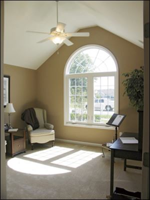 This stunning room may be used as an office or a bedroom. Its tall ceiling, palladian window and ceiling fan have a classic appeal.