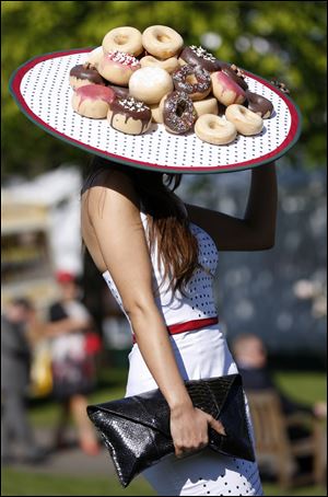 A racegoer arrives at Aintree Ladies Day at the Grand National horse race meeting last week at Aintree racecourse in Liverpool, England, wearing a doughnut hat.