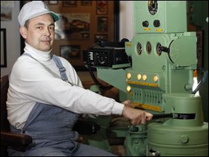 Steve Rathke works a control stand from a 1951 General Motor locomotive, including an operator's chair and control panel with throttle and brake handles that he restored.