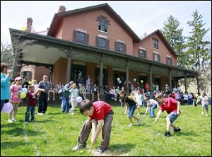 Children compete in the egg-rolling race as spectators line the porch of the Hayes mansion. The annual event commemorates President Rutherford B. Hayes’ starting the annual egg roll at the White House.