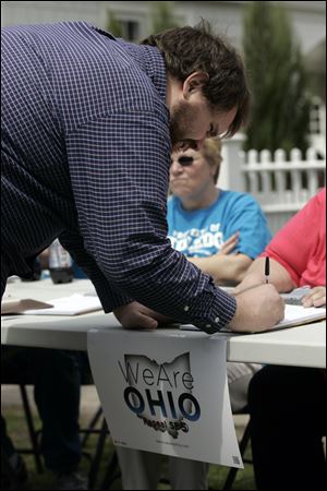 Matthew Barbee of Bowling Green signs the petition to put repeal of Senate Bill 5 on the November ballot.