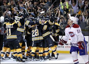 Montreal Canadiens center Jeff Halpern (15) looks up as Boston Bruins players celebrate the game-winning goal by Nathan Horton in overtime. 