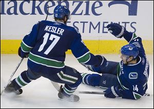 Vancouver Canucks' Alex Burrows, right, celebrates his game winning goal with teammate Ryan Kesler during the overtime period against the Chicago Blackhawks in game 7.