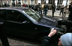 Photo media journalists crowd around the car belonging to Kate Middleton as she leaves her London home in this file photo.
