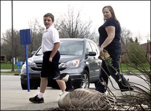 Logan Blockway, 11, left, and his mother, Hanna Blockway, take a gander at a mother goose perching atop her eggs near the entrance to the post office on South Detroit Avenue.