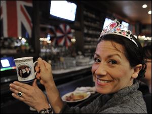 Valerie Malas holds a mug with a photo of Prince William and Kate Middleton to commemorate the couple's royal wedding while she watches the wedding live on television at the Globe Pub in Chicago.