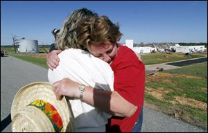 An emotional Donna Fredericks, right, cries as she hugs a former worker, Martha Mitchell, while they speak about mutual friends at the VF Jeans Wear Distribution Center in Hackleburg, Ala.