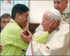 Pope John Paul II, right, greets a young man during a mass at the Cathedral of the Immaculate Conception in Denver in this Aug. 15, 1993 file photo.