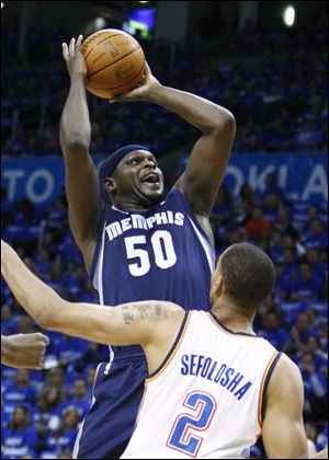 Memphis Grizzlies forward Zach Randolph, left, shoots in front of Oklahoma City Thunder guard Thabo Sefolosha in the first quarter of Game 1 of a second-round NBA basketball playoff series in Oklahoma City.