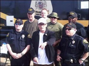 Actor Charlie Sheen poses with police officers and National Guard soldiers Monday in Tuscaloosa, Ala. Sheen said Monday he is organizing a relief event for tornado victims in this Alabama town. 