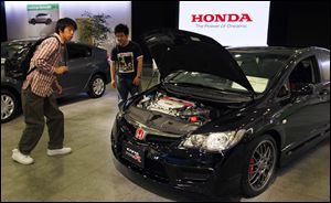 Visitors look at Honda Civic Type R at a Honda Motor Corp. showroom in Tokyo. Dealers were warned by the company Monday that it will run short of some models, including the Civic, because of parts shortages.