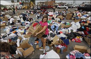 Volunteer Brooke Jackson of Tuscaloosa, Ala., helps organize items donated for tornado victims. Federal officials will make loans available to help with rebuilding. 