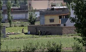 Pakistan army soldiers rest near the house where it is  believed al-Qaida leader Osama bin Laden lived in Abbottabad, Pakistan on Monday. 