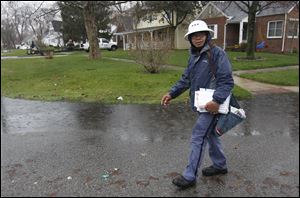 Rolando Buno skirts a pool of water in a front yard as he delivers mail in the rain along Heatherdowns Boulevard in mid-April. He said he's been braving the elements for 17 years.