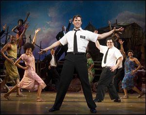 Andrew Rannells, center, and Josh Gad, right, play missionaries to Africa
in ‘The Book of Mormon.’