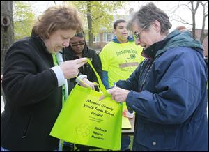 Denise Reaume, of Newport, the 4-H program associate for Monroe County Green Growers 4-H club, left, gives a bag and worms for composting to Anne Wisda, of Monroe, right.