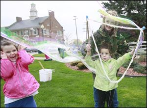 Taegen Payne, 5, of Newport, Mich., left, reacts to the expanding soap bubble made by Allison Callahan, 3, of Brighton, with the help of Kayleigh Adams, 13, of Monroe. 