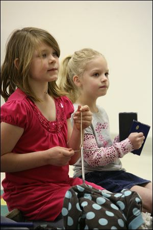 Allie Hummel, 6, and Kendra Louy, 7, play musical instruments during the National Jellybean celebration at Swanton Public Library. 