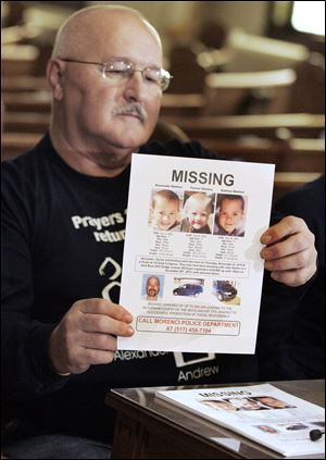 Don Zuvers, grandfather of three missing boys, holds a poster with their pictures. Mr. Zuvers was at a news conference Tuesday at First United Methodist Church in Morenci, Mich., where he asked people to be alert to their surroundings and report anything that may be the remains of Andrew, 9, Alexander, 7, and Tanner, 5, who have been missing since Thanksgiving.