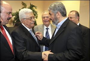 Palestinian President Mahmoud Abbas, center-left, and Hamas leader Khaled Mashaal, center-right, shake hands at a ceremony in Cairo, Egypt.