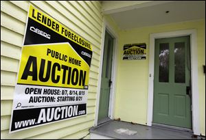 A home in Chagrin Falls, Ohio, has a foreclosure auction sign displayed in it.