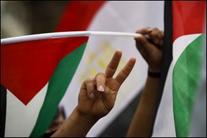 Palestinians gesture and wave the Palestinian and Egyptian flags Wednesday as they take part in a rally in the West Bank city of Ramallah celebrating the signing of a reconciliation agreement between Fatah and Hamas.