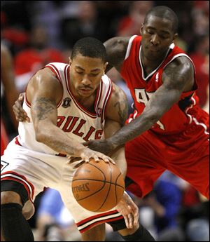 Newly-crowned MVP Derrick Rose of the Chicago Bulls, left, is hounded by Atlanta's Jamal Crawford in the fourth quarter Wednesday in Game 2. The Bulls pulled away late for a 86-73 win to even the series at one game apiece.