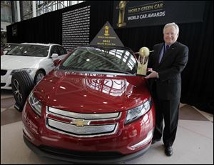 Rick Scheidt, Chevrolet vice president of U.S. Marketing, stands by a Chevrolet Volt with the award as the 2011 Green Car presented at the New York International Auto Show on April 21.
