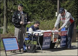Associated pressTeamsters Matt Ford, left, Eric McKee, and Charles Smith collect signatures on petitions to repeal Ohio's collective bargaining law. The union members were outside Cleveland Metroparks Zoo Thursday.