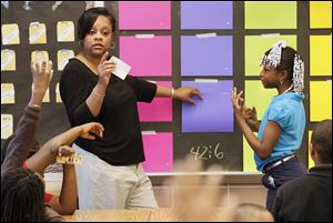 Teacher Donna Garth waits for an answer from Jazzlyn Whitlow, 9, right, during a ‘Jeopardy’-like math game in her third-grade classroom at Pickett Academy. Pickett is Toledo’s most chronically poor performing school, but a closer look at the data shows students at the central-city school are making progress.