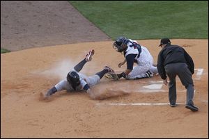 Mud Hens catcher Omir Santos tags out Lehigh Valley’s Delwyn Young at home plate in Monday night’s game at Fifth Third Field.