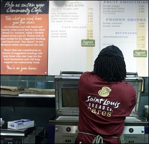 An employee tends to an order in the Panera restaurant in Clayton, Mo., where the charitable concept started.