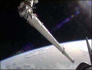 Space shuttle Endeavour's robotic arm grapples the orbiter boom sensor system. 