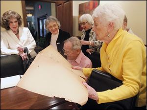 Joyce Dennison holds a scrapbook as she joins class of 1944 members Kleo Boyles, left, Madelyn Botek, Bob Nusbaum, and JoAnn McCloskey at their most recent luncheon. 
