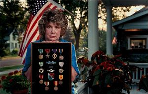 Joyce Wood, with her late husband's medals, says he was 'very disturbed' by his experiences in Vietnam.