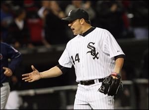 Chciago White Sox' pitcher Jake Peavy reaches to shake hands with catcher AJ Pierzynski after throwing a complete game three-hitter to  defeat the Cleveland Indians.