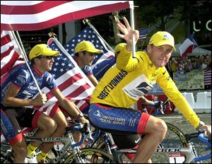 Lance Armstrong, right, rides down the Champs Elysees avenue with his teammates Georges Hincapie, and Tyler Hamilton, left, after he won the Tour de France cycling race in 2001.